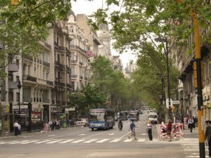 Fotografía de la Avenida de Mayo de Buenos Aires, una larga avenida con edificios y árboles a ambos lados